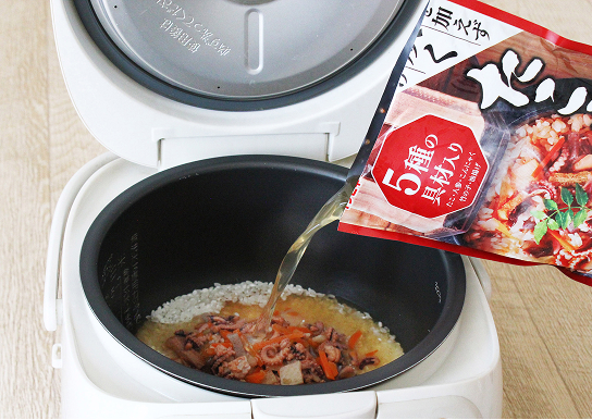 たこめしの素の素を炊飯器に注ぐ写真